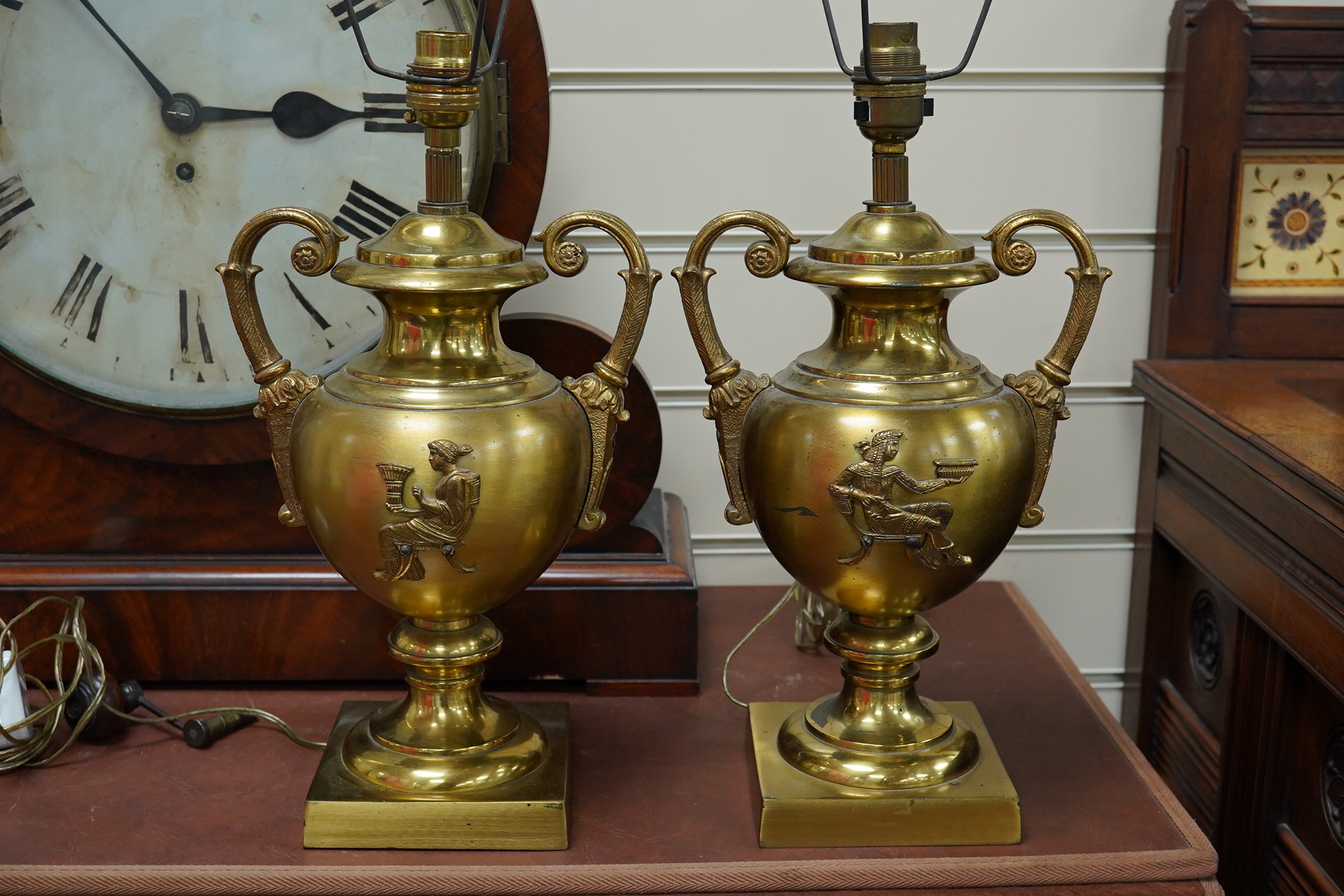 A pair of Empire style brass lamps with twin handles and applied decoration, 36cm high including the fitting. Condition - fair to good, untested